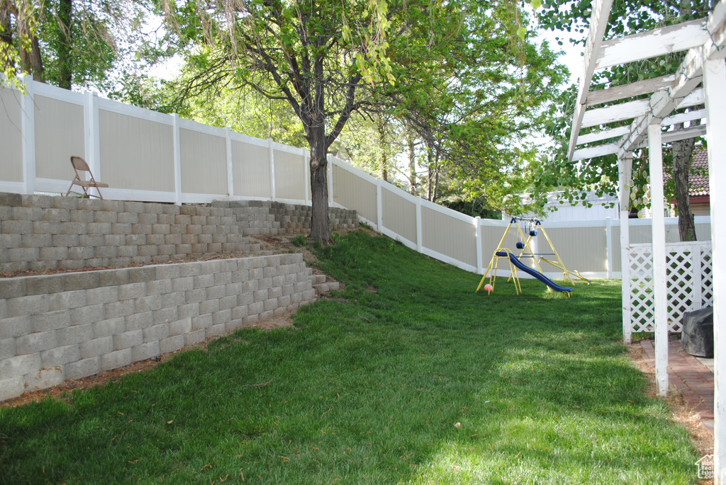 View of yard with a playground and a pergola