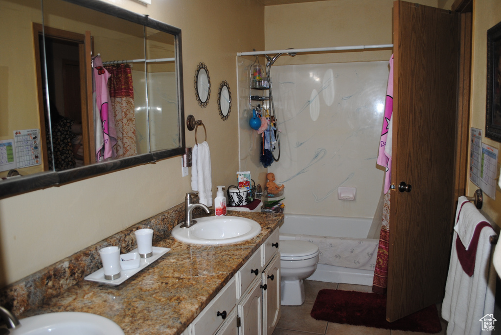 Full bathroom with a shower with shower curtain, tile patterned floors, double vanity, and toilet