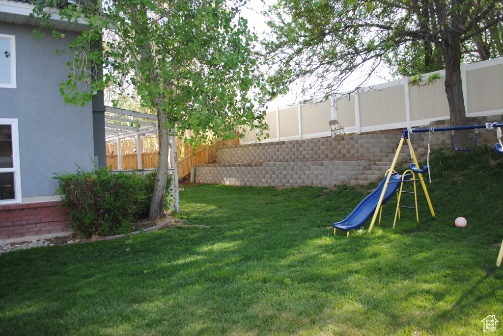 View of yard featuring a playground and a trampoline