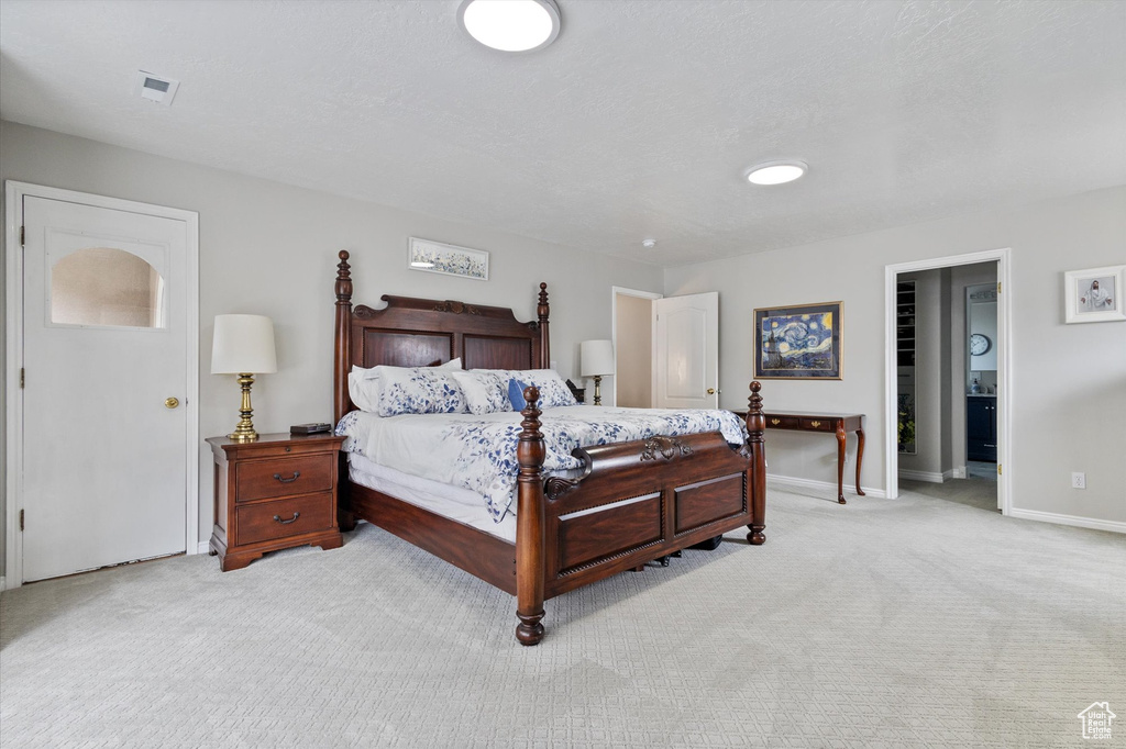 Bedroom featuring light colored carpet and baseboards