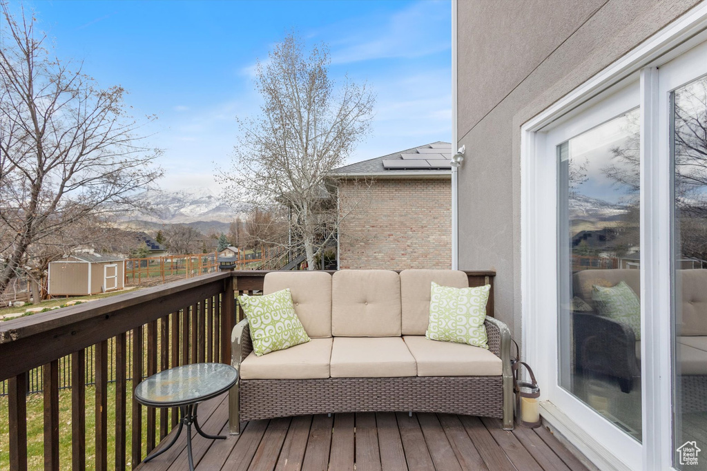 Wooden deck with a storage unit, a mountain view, an outbuilding, and outdoor lounge area
