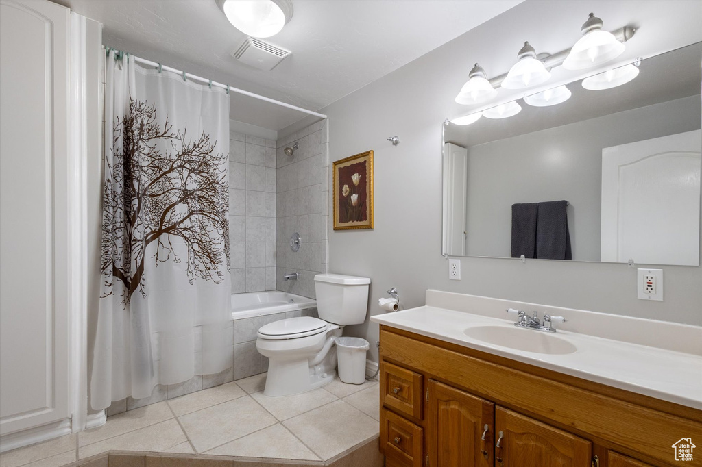 Full bath featuring tile patterned floors, shower / bath combination with curtain, vanity, and toilet