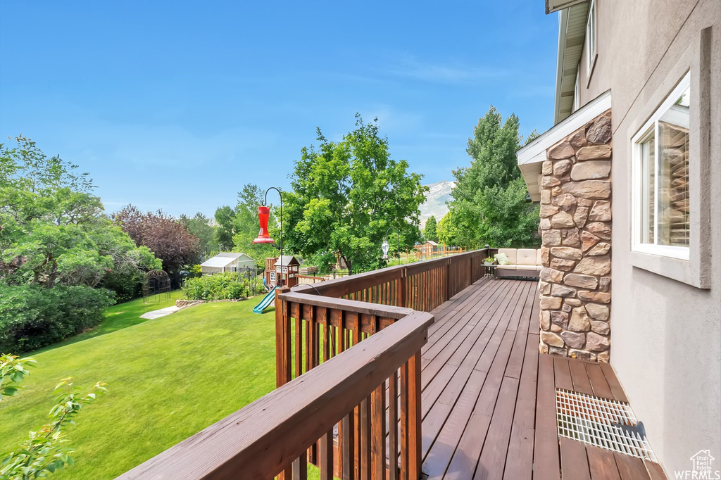 Wooden deck with a playground and a yard