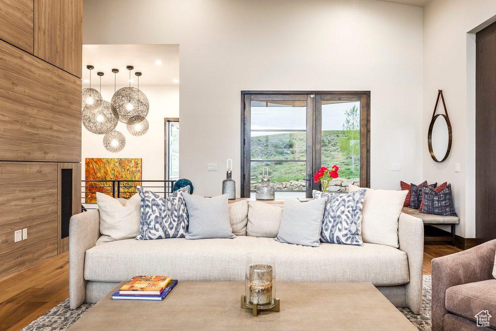 Living area with wood finished floors, a towering ceiling, recessed lighting, and a chandelier