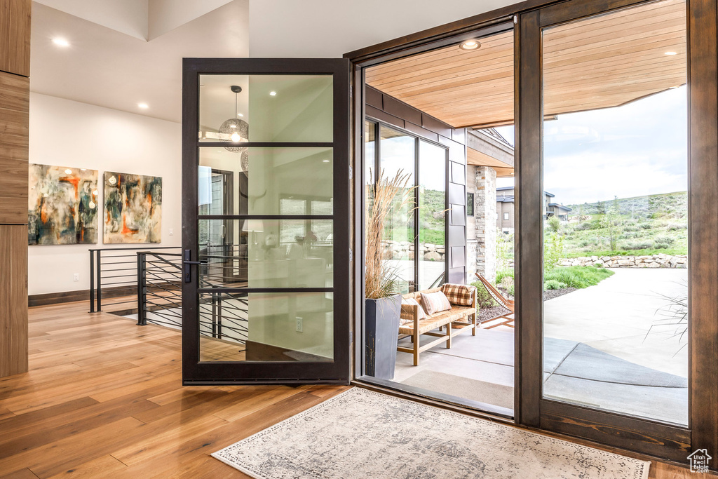 Doorway with wood finished floors, recessed lighting, and baseboards