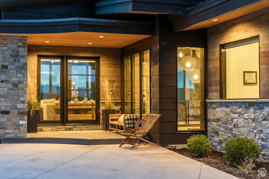 Property entrance featuring stone siding and a porch