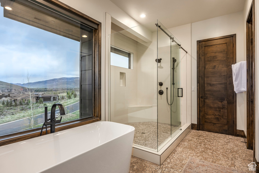 Full bathroom featuring a shower stall, a freestanding bath, a mountain view, and recessed lighting