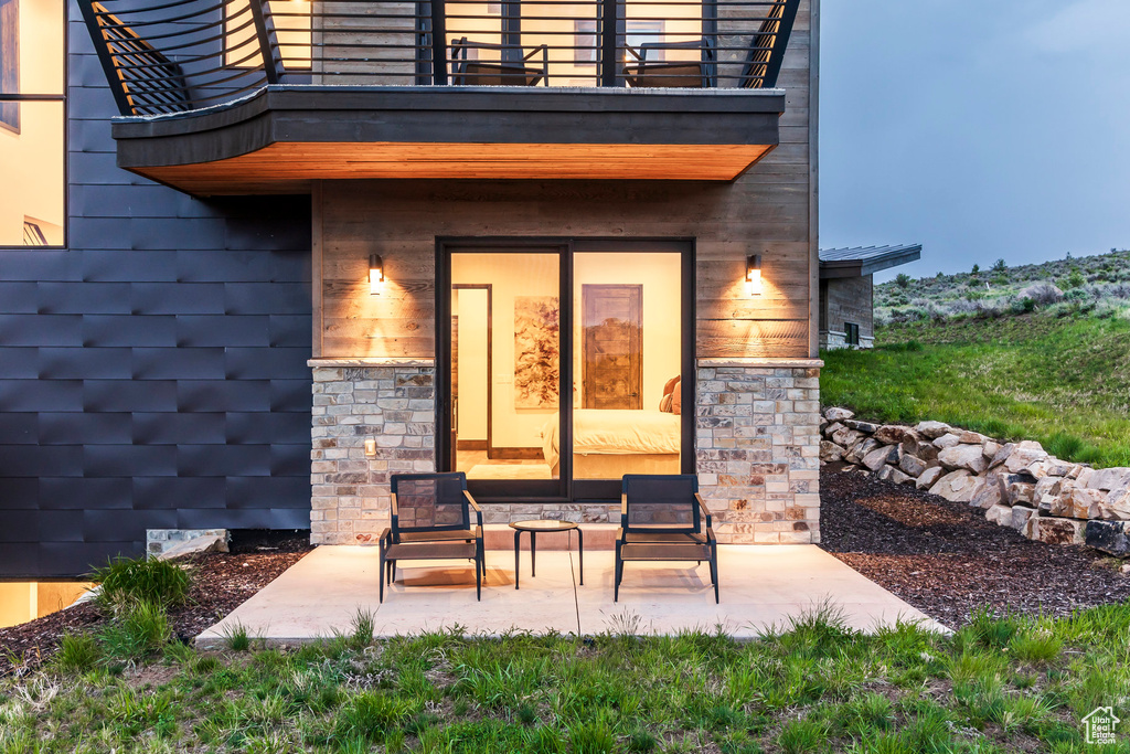 Property entrance with a balcony and a patio