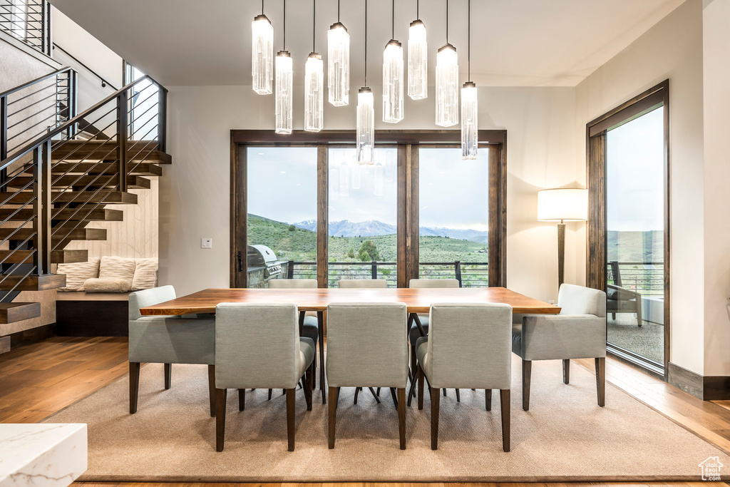 Dining area with wood finished floors, a mountain view, and stairway