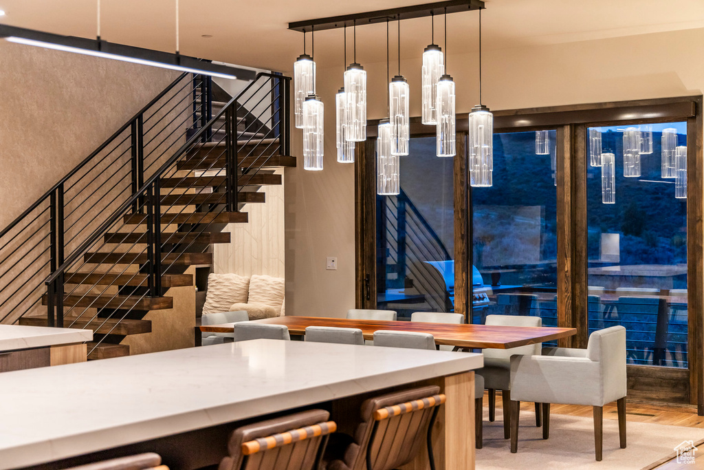 Dining space with stairs and wood finished floors