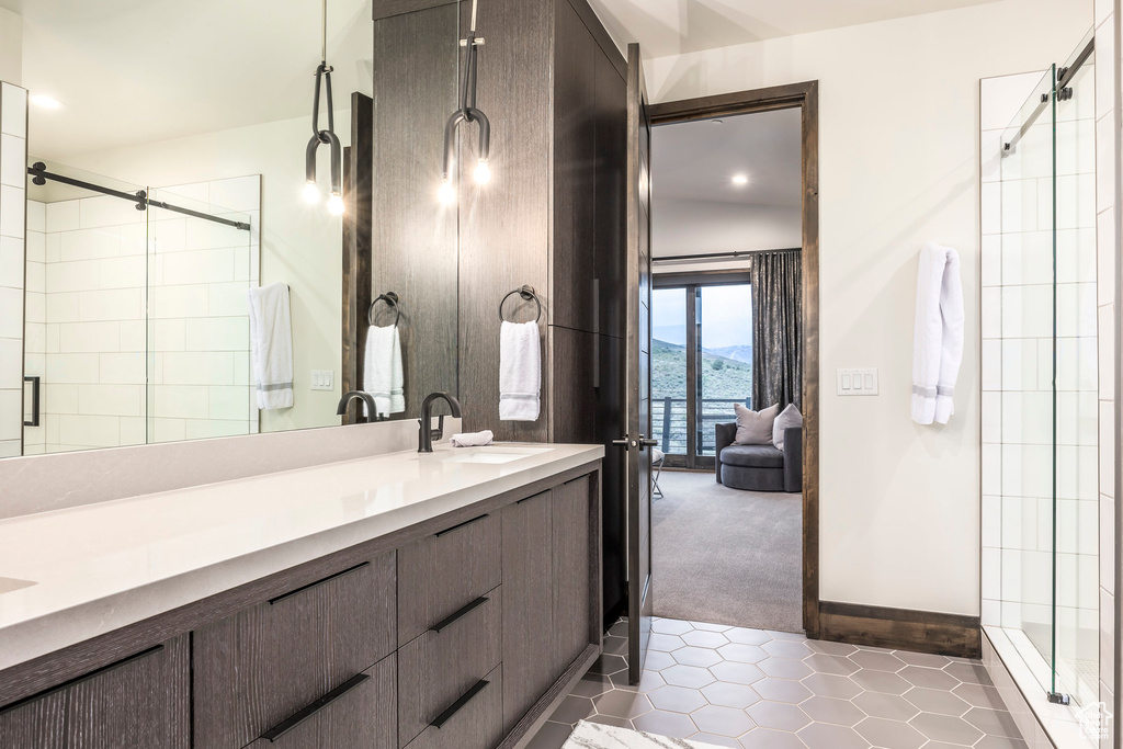 Full bathroom featuring tile patterned flooring, a shower stall, double vanity, recessed lighting, and baseboards