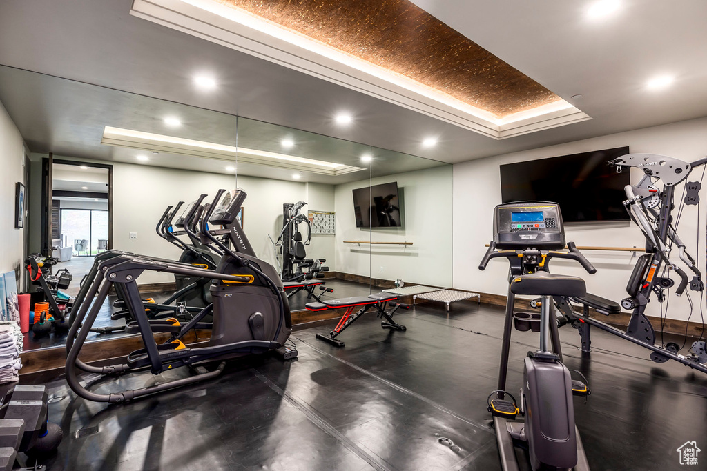 Workout area featuring baseboards and a tray ceiling