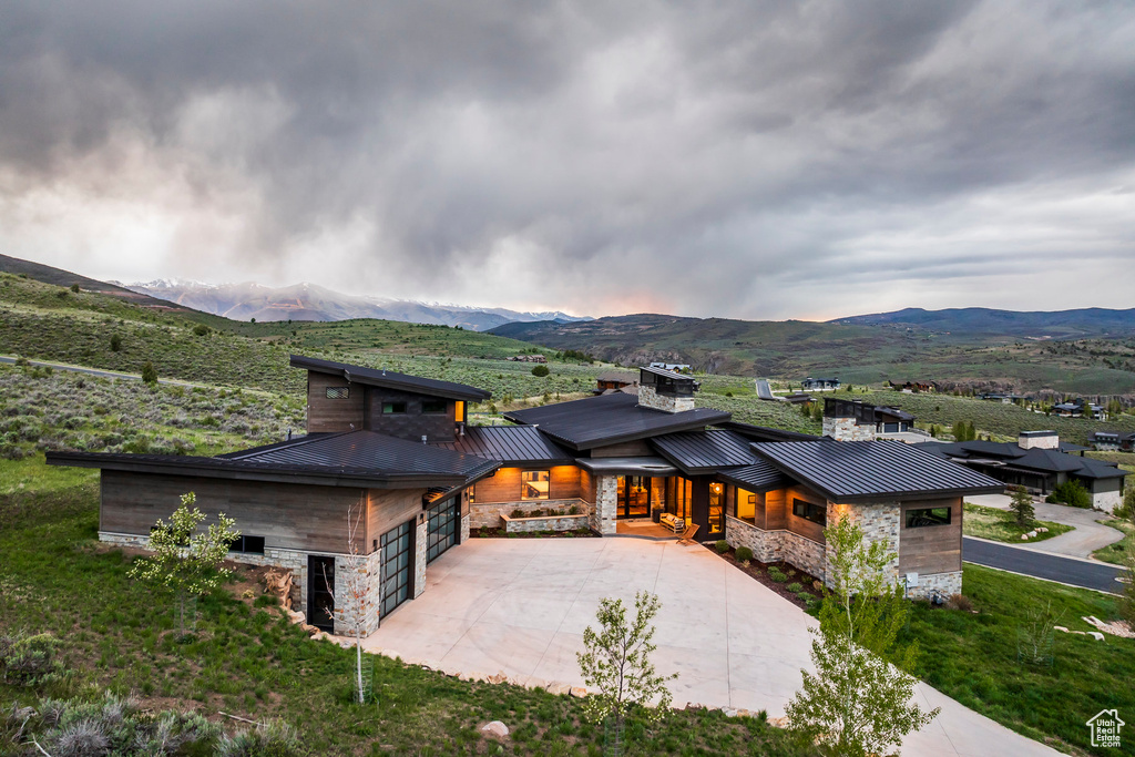 View of front facade with a standing seam roof, stone siding, and a mountain view