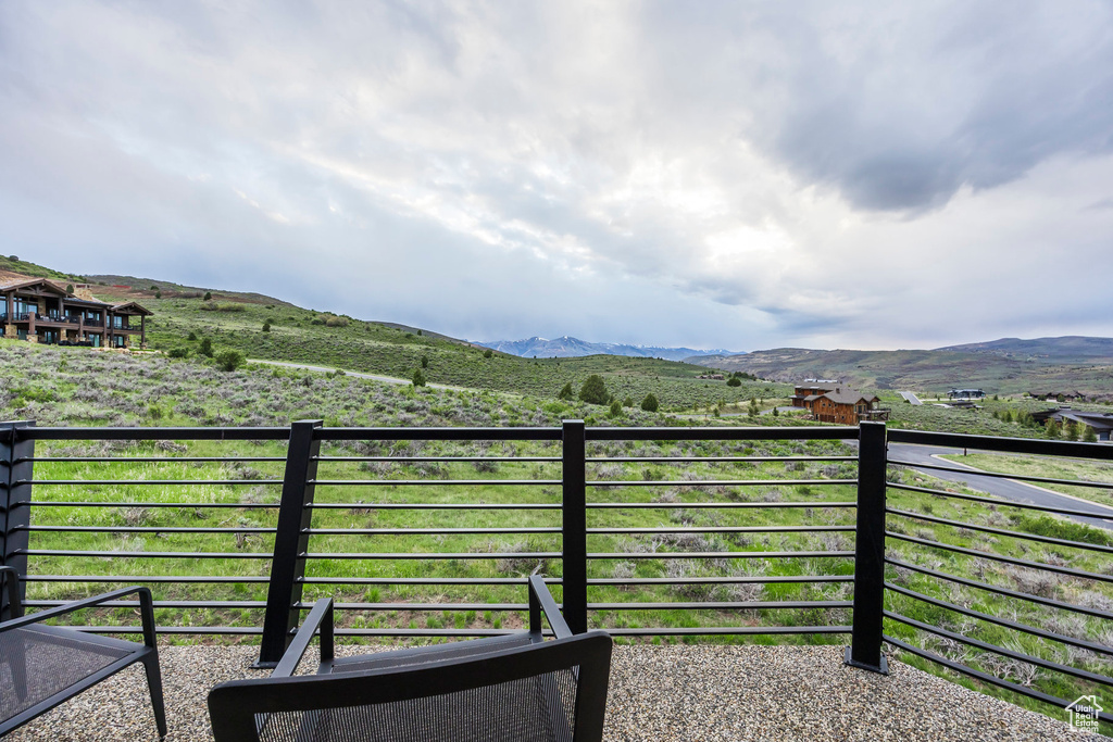 View of yard with a balcony and a mountain view
