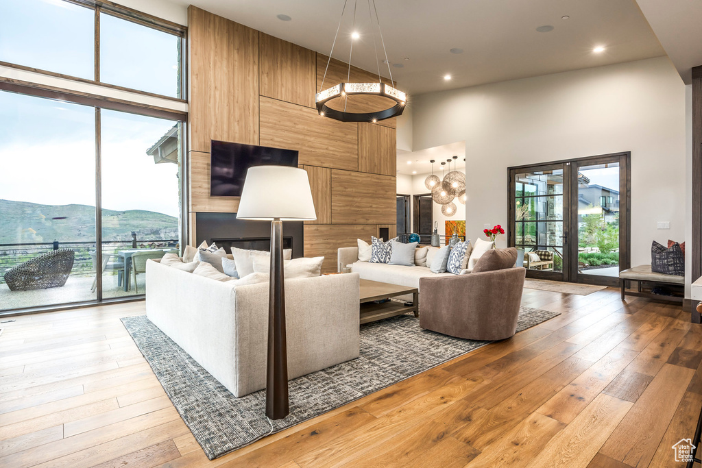 Living area with a high ceiling, light wood finished floors, and recessed lighting