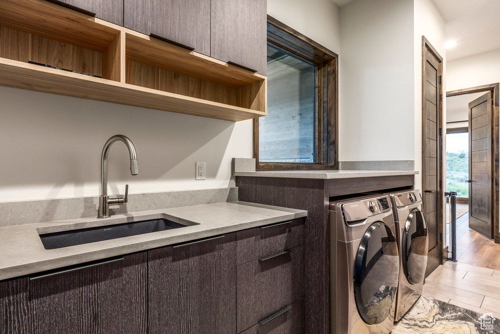 Washroom featuring independent washer and dryer and cabinet space