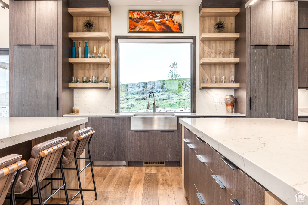 Kitchen featuring open shelves, a sink, and modern cabinets
