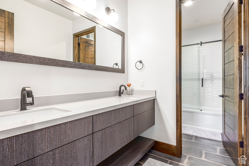 Full bathroom featuring double vanity and bathing tub / shower combination