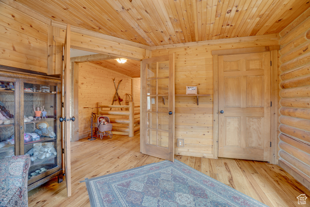 Unfurnished bedroom with rustic walls, hardwood / wood-style flooring, wood ceiling, and wood walls