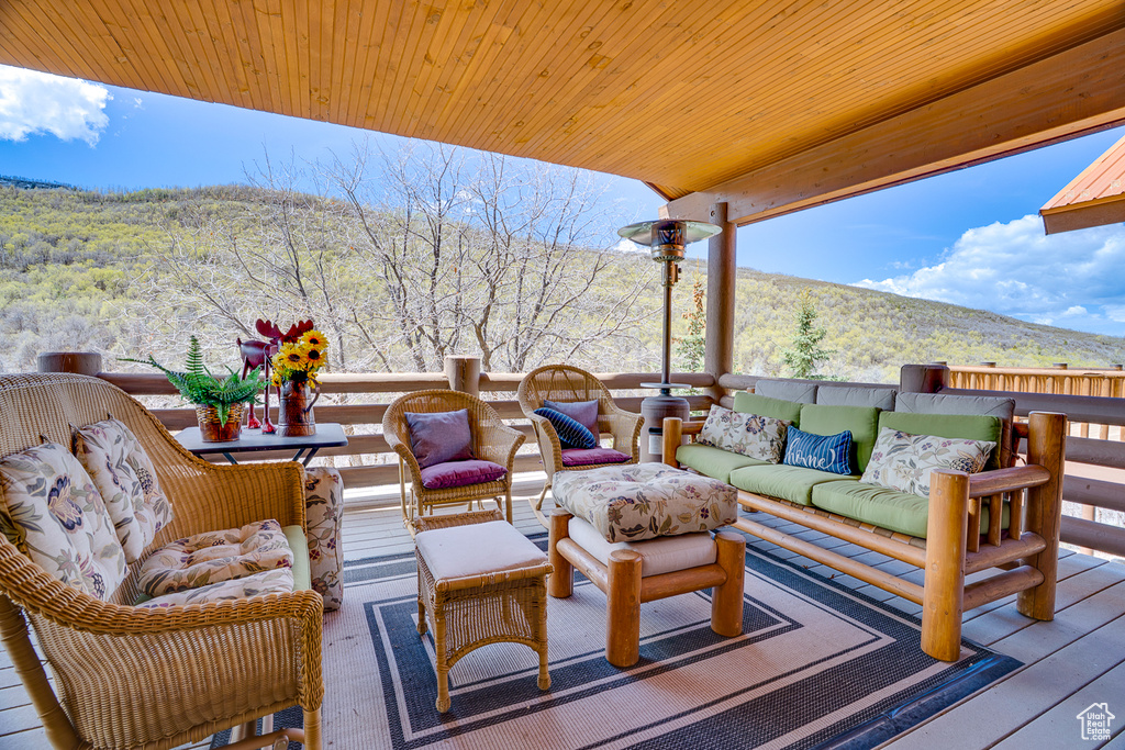 Wooden deck featuring an outdoor living space and a view of trees