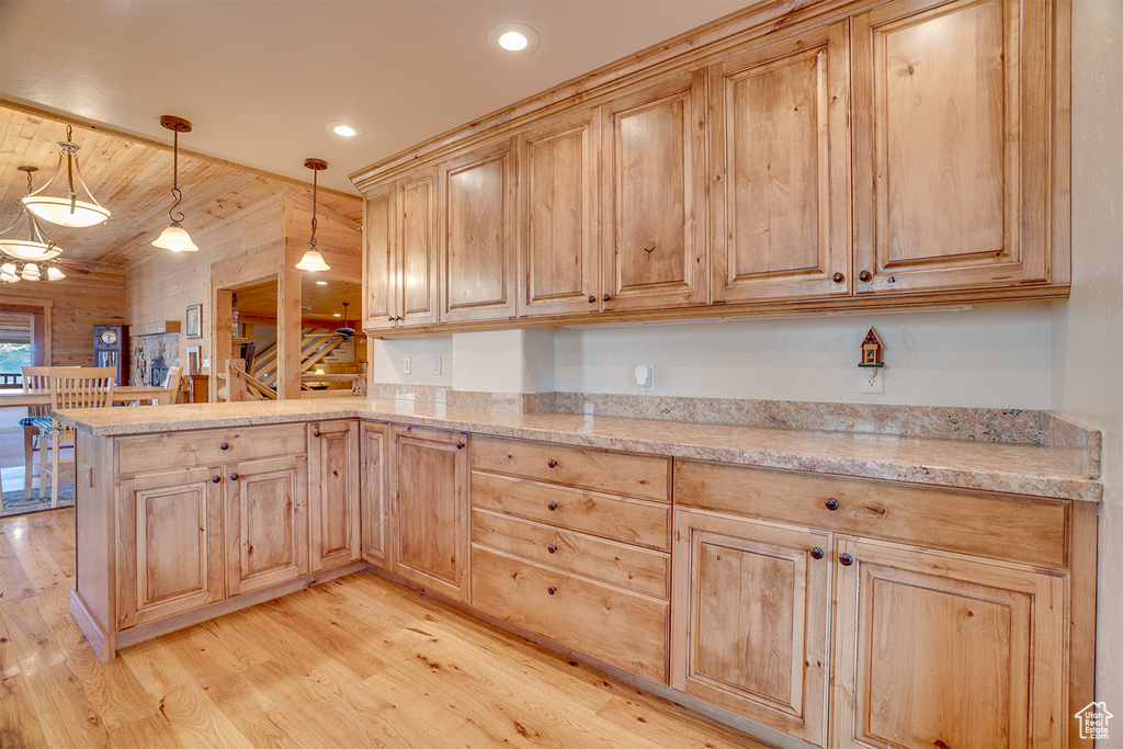 Kitchen featuring light brown cabinetry, light wood-type flooring, a peninsula, pendant lighting, and recessed lighting