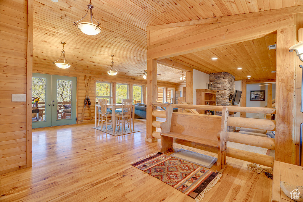 Living area with wood ceiling, french doors, wood finished floors, rustic walls, and stairs