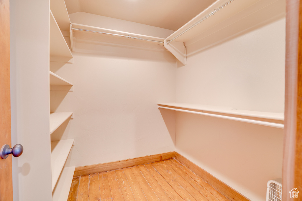 Walk in closet with wood-type flooring