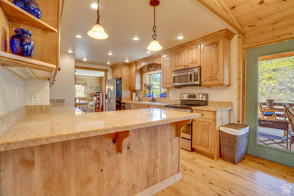 Kitchen with appliances with stainless steel finishes, light wood finished floors, recessed lighting, a peninsula, and open shelves