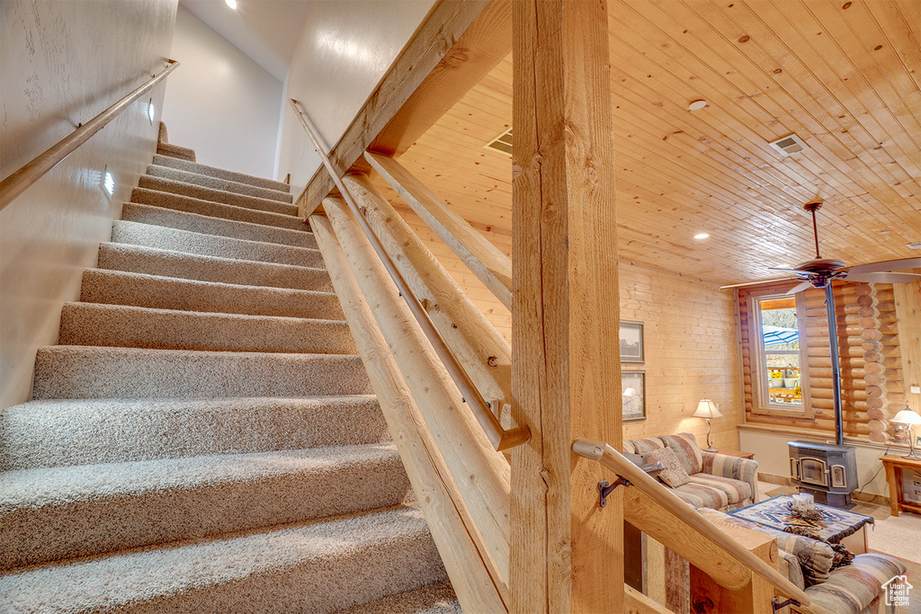 Stairs with a wood stove, wood ceiling, recessed lighting, and ceiling fan