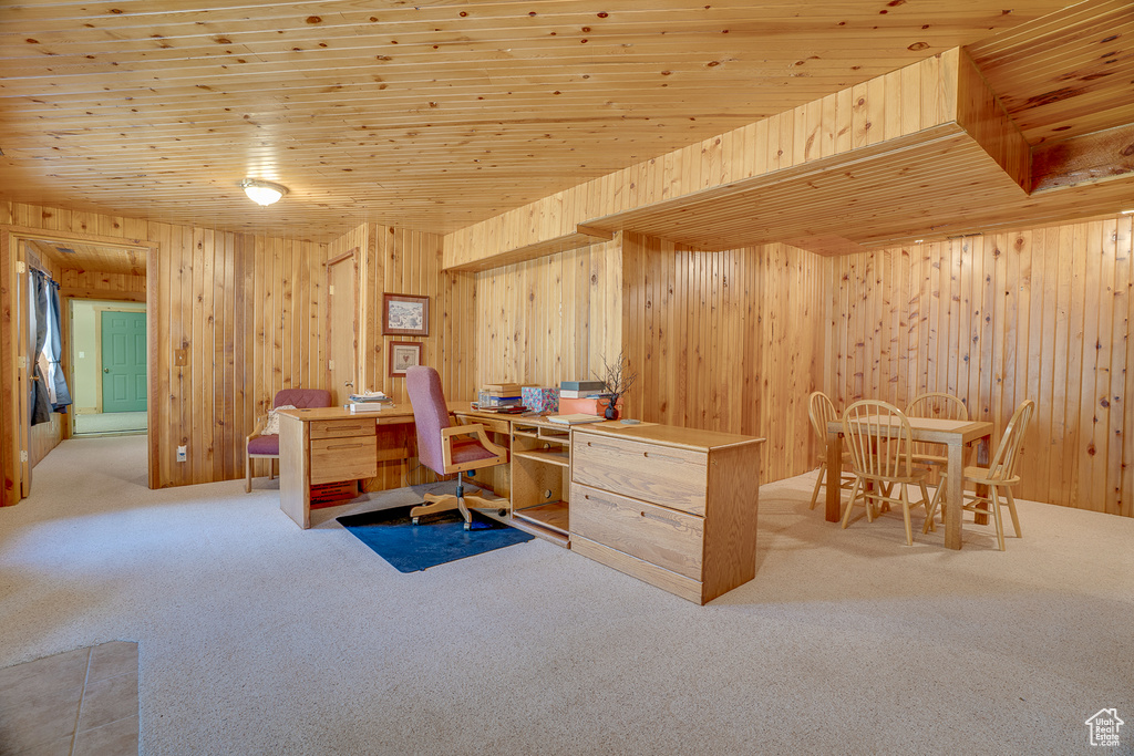 Office area featuring light colored carpet, wooden walls, and wooden ceiling