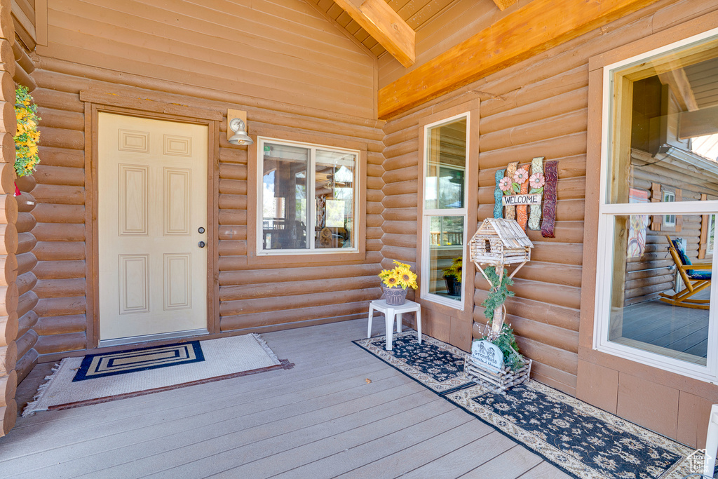 Entrance to property with covered porch and log siding