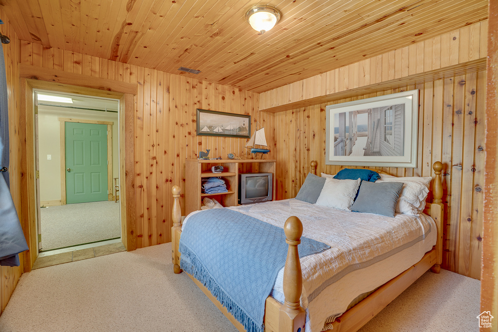 Bedroom featuring carpet floors and wood walls