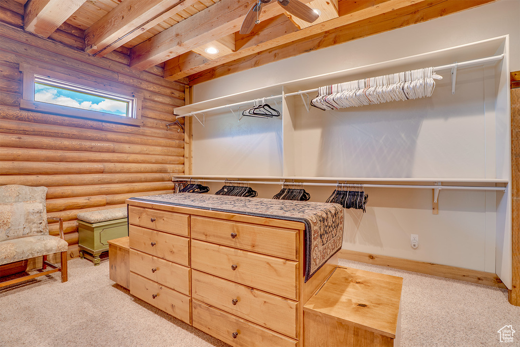 Walk in closet with carpet floors and beam ceiling