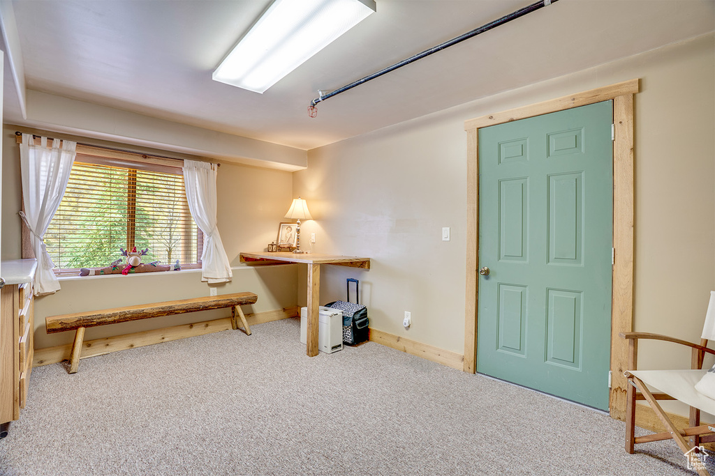 Living area featuring carpet flooring and baseboards