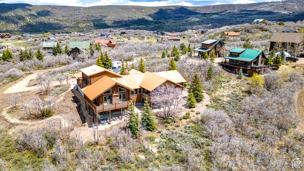 Aerial view of property and surrounding area with a mountain backdrop