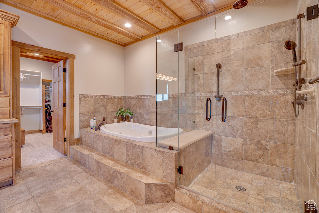 Bathroom featuring wooden ceiling, a stall shower, a bath, beamed ceiling, and a walk in closet