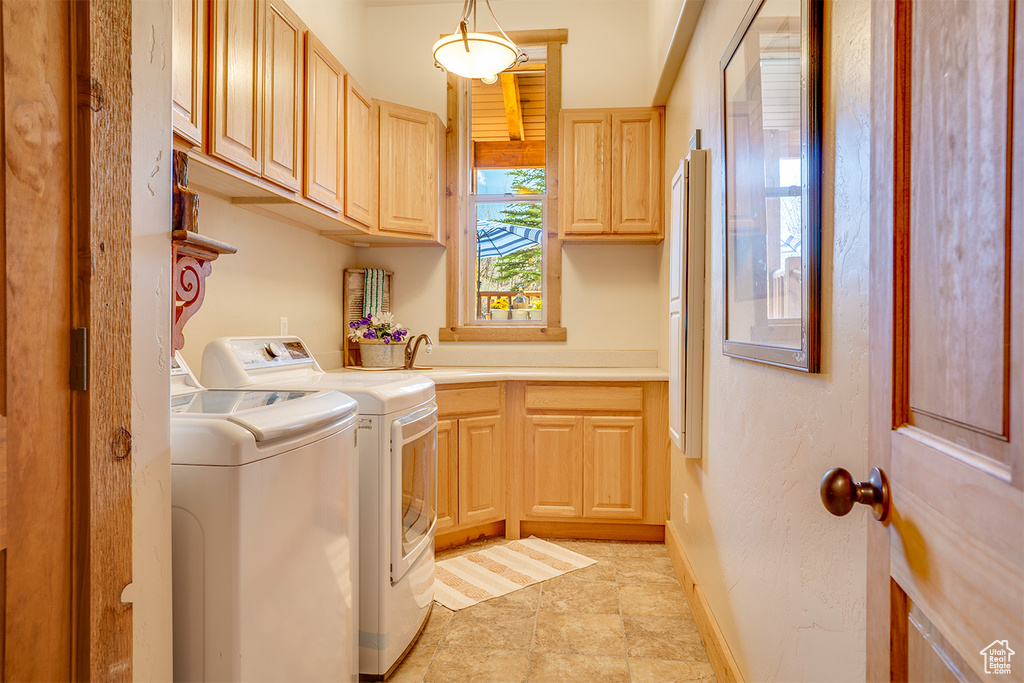Laundry area with washer and clothes dryer, cabinet space, and baseboards