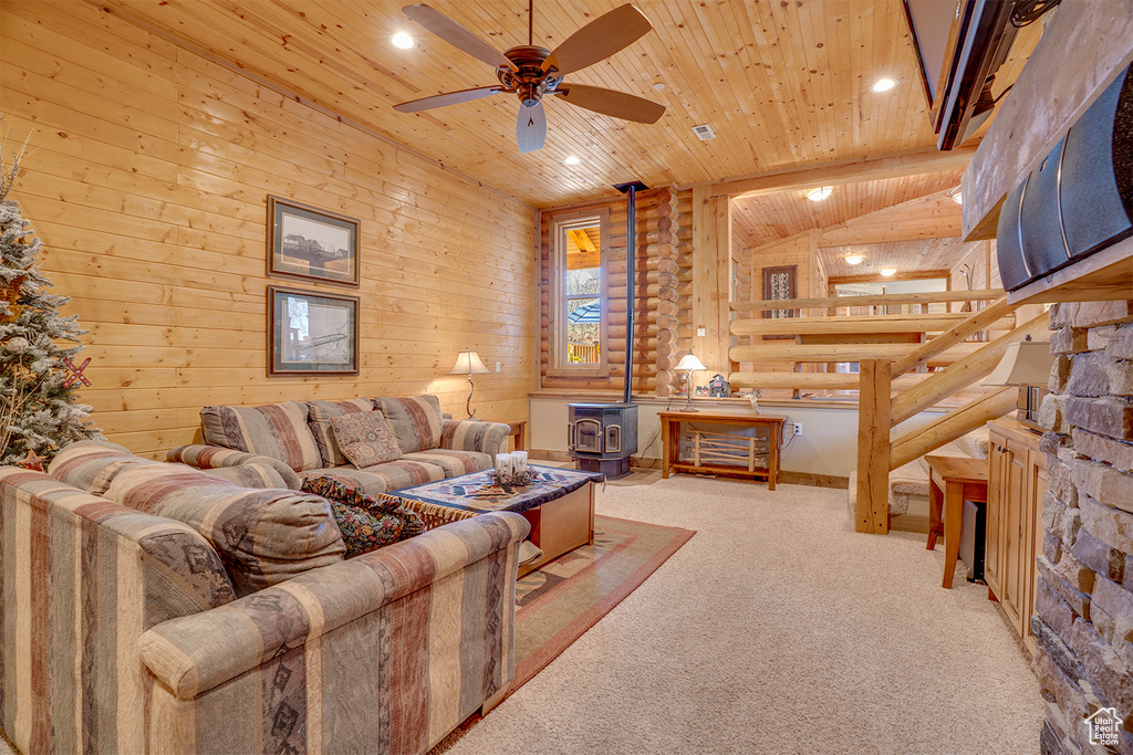 Living room with wooden ceiling, a wood stove, ceiling fan, carpet flooring, and recessed lighting