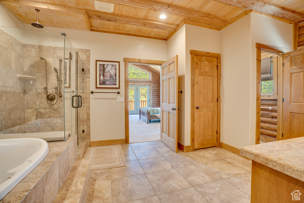 Ensuite bathroom with wooden ceiling, baseboards, a shower stall, a bath, and vanity