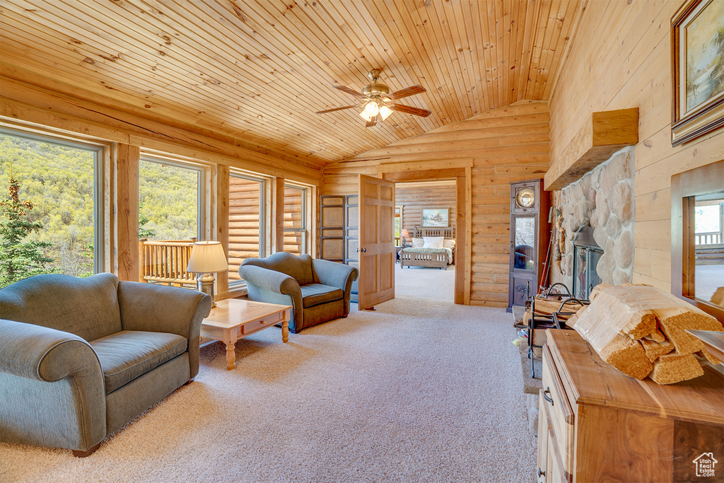 Living room featuring lofted ceiling, wooden ceiling, a ceiling fan, carpet flooring, and a fireplace