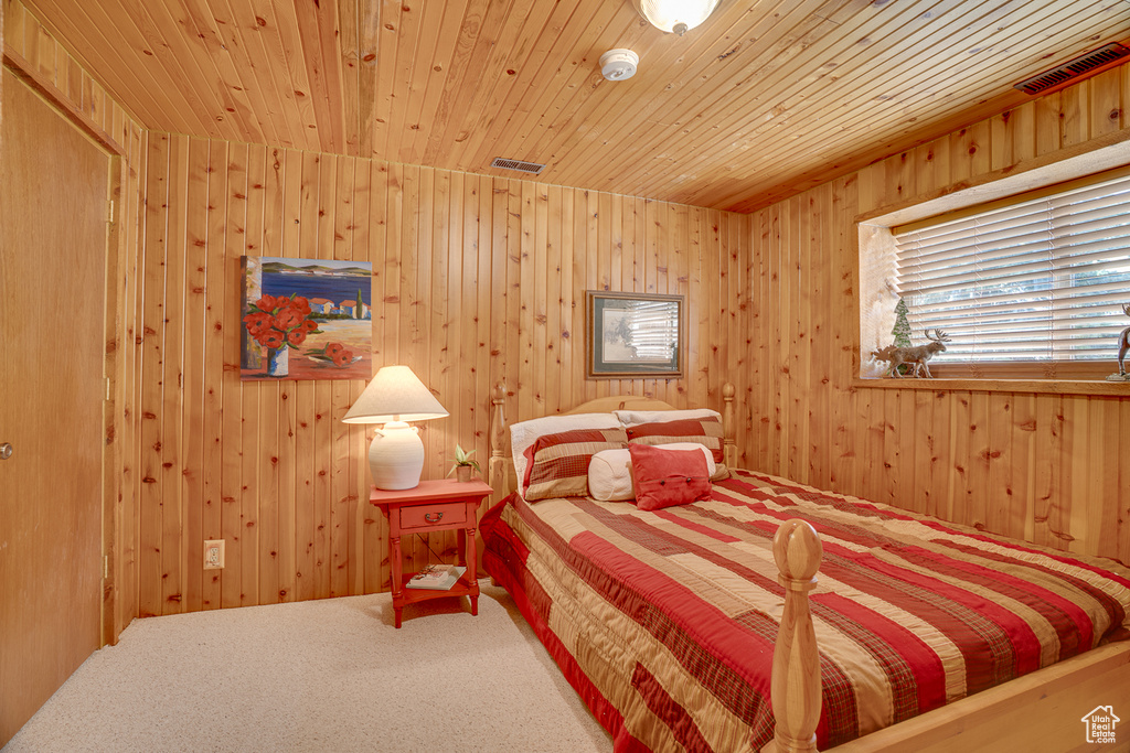 Bedroom with carpet floors, wood ceiling, and wood walls