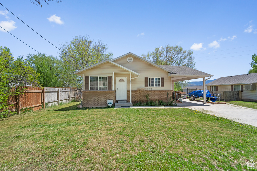 View of front of home with brick siding, entry steps, concrete driveway, and a carport
