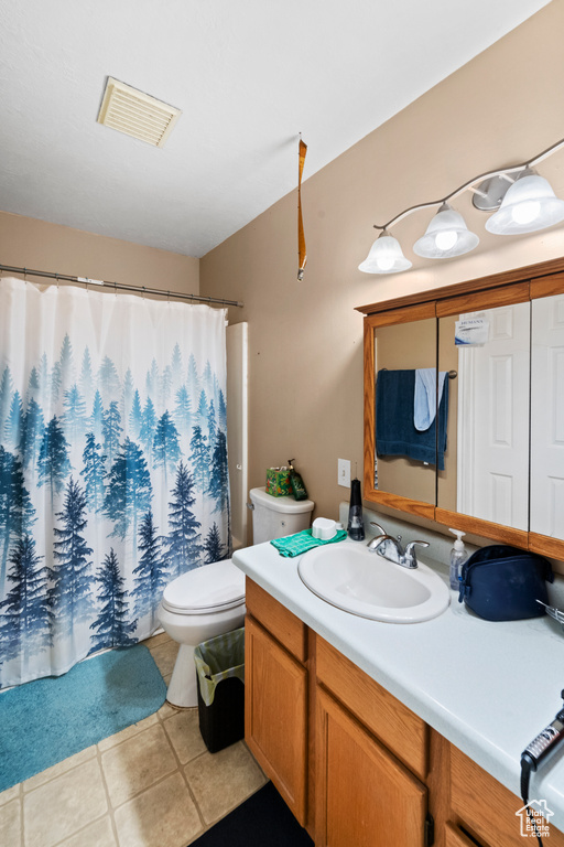 Full bath featuring tile patterned flooring, vanity, toilet, and a shower with shower curtain
