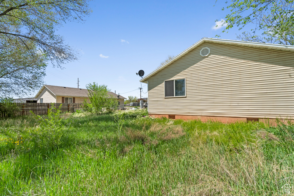 View of property exterior with crawl space and fence