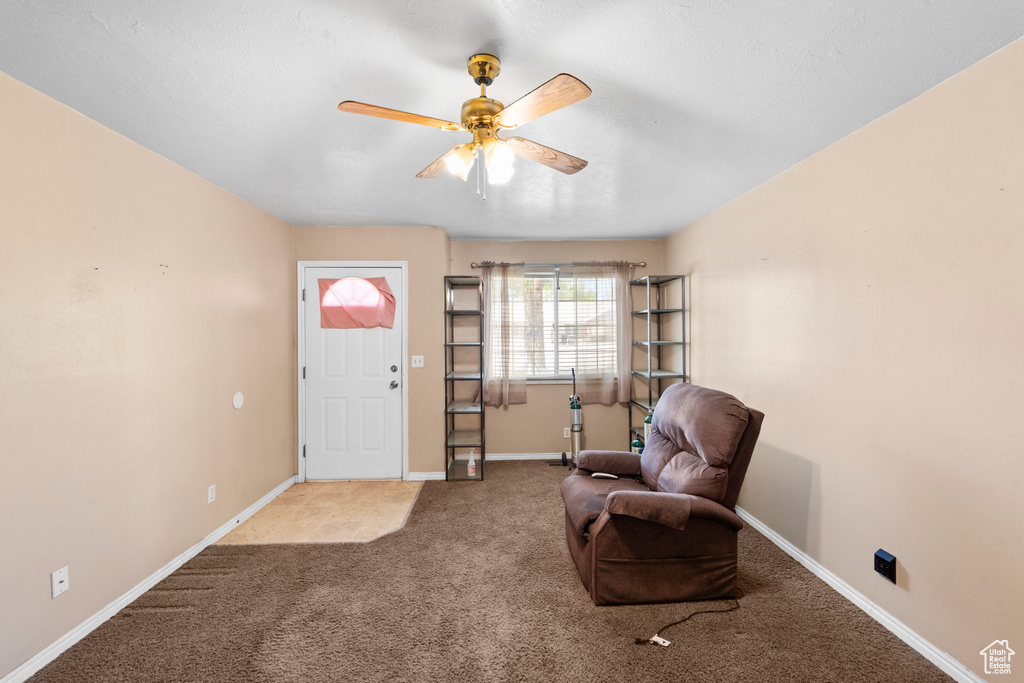 Sitting room featuring carpet floors, a ceiling fan, and baseboards
