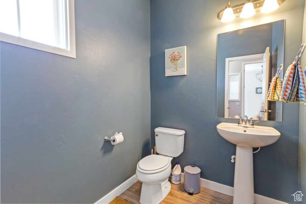 Bathroom with a sink, baseboards, toilet, and wood finished floors