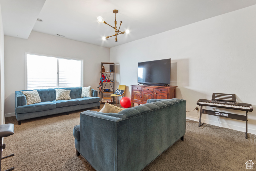 Carpeted living room with an inviting chandelier and baseboards