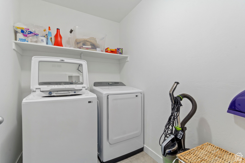 Laundry room featuring laundry area, washing machine and dryer, and light tile patterned floors