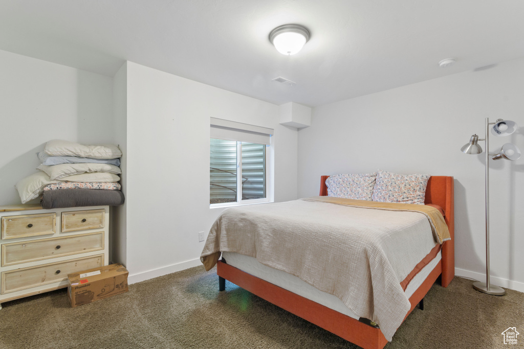 Carpeted bedroom with baseboards and visible vents
