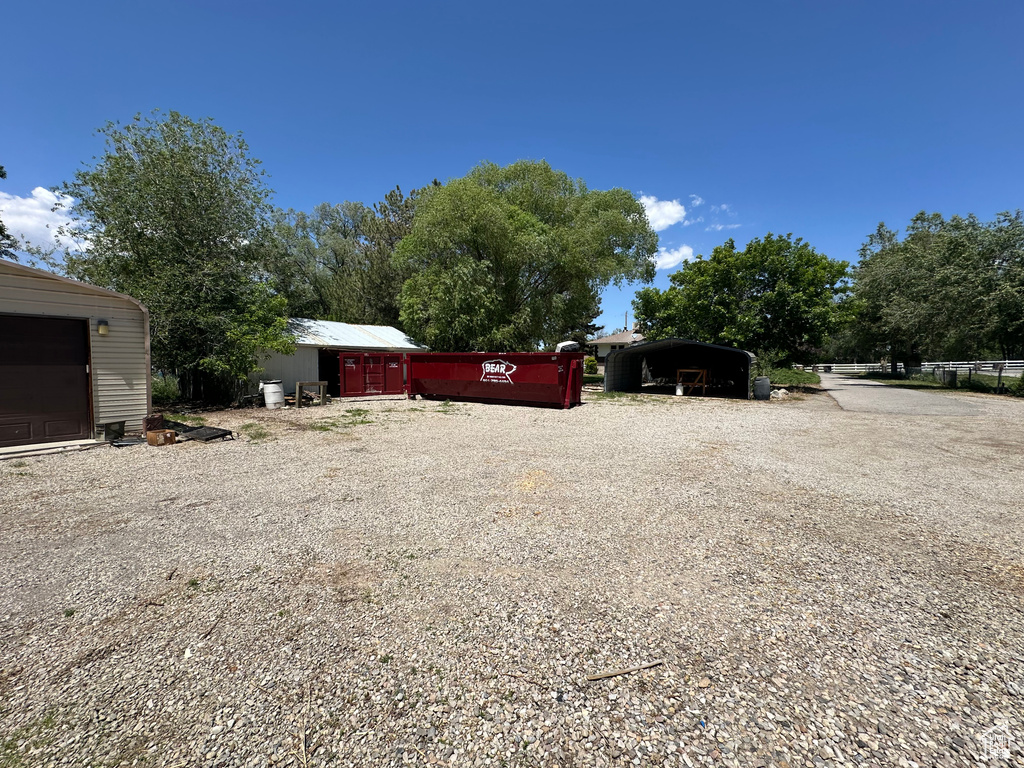 View of yard with driveway and a detached carport